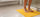 Person standing on a yellow mat in a bathroom